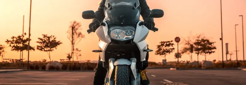 A motorcyclist on an empty road at sunset