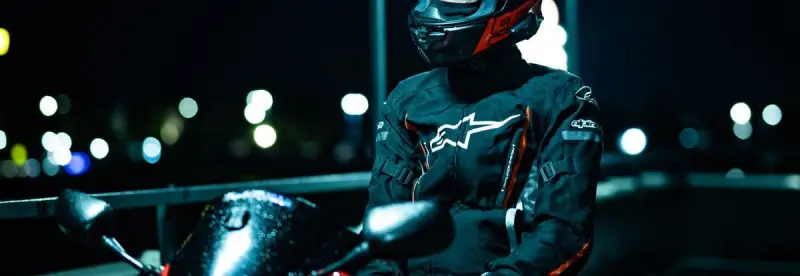 A rider in black gear at night