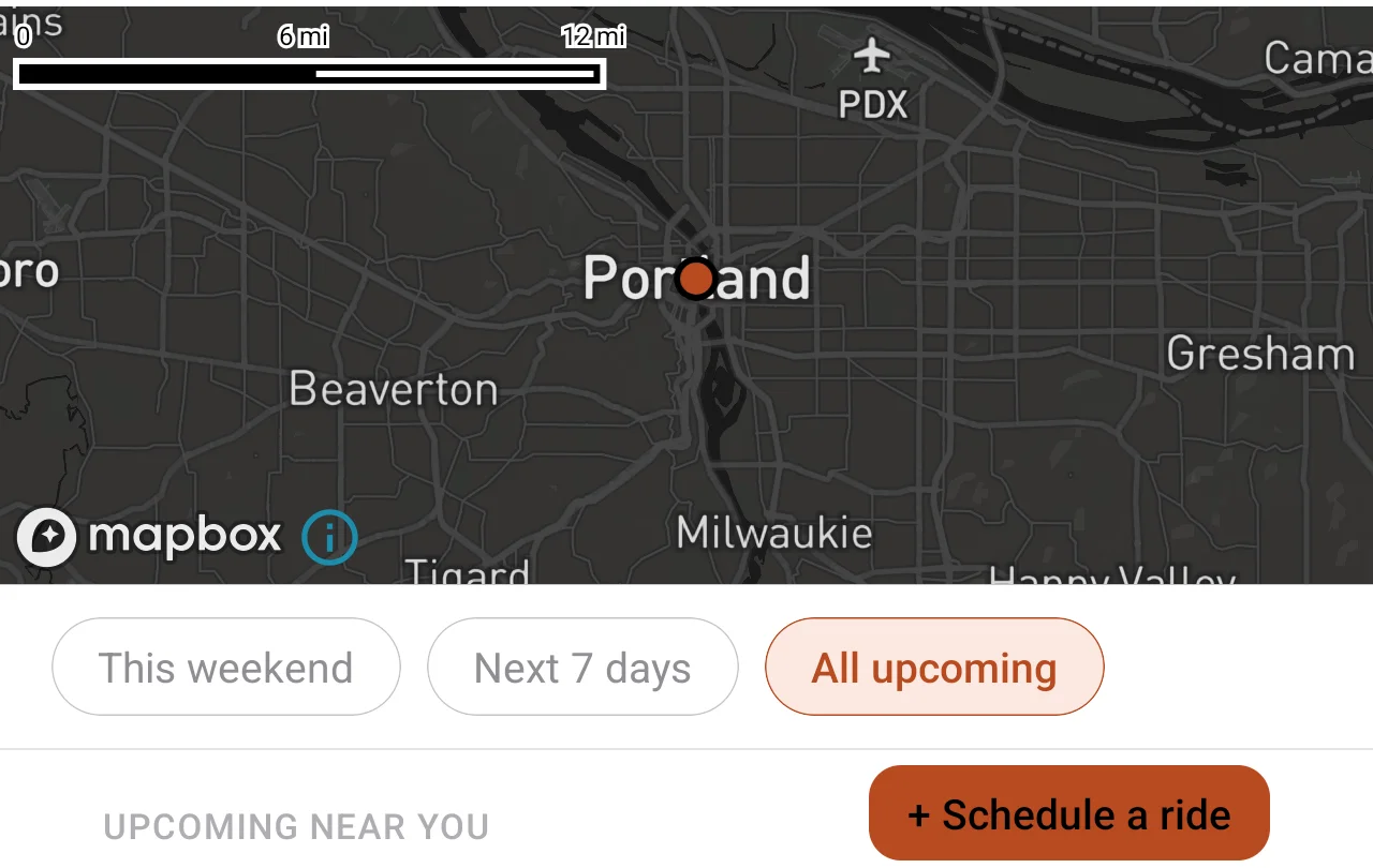 Rides screen in 2 Wheels in Common showing a real regional map with date filters for this weekend, next 7 days and all upcoming, where a sponsored ride would surface to nearby riders